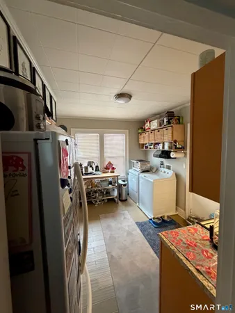 a storage room with stainless steel appliances lots of appliances and cabinets