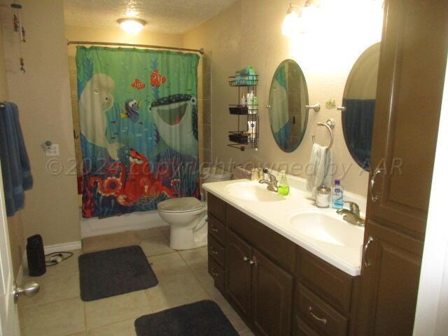 4243 Camp Lane Amarillo, TX 79110 - Photo 6 of 17 a bathroom with a double vanity sink toilet and shower