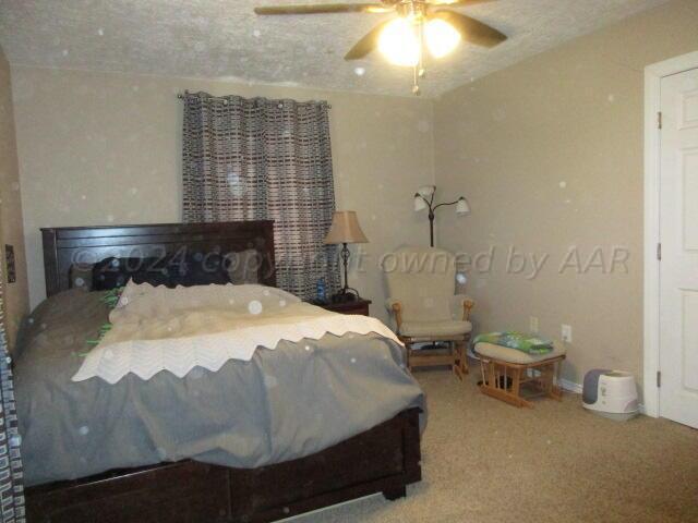 4243 Camp Lane Amarillo, TX 79110 - Photo 8 of 17 a bedroom with a bed and a chandelier