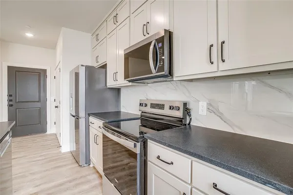 a kitchen with stainless steel appliances granite countertop a refrigerator microwave and sink