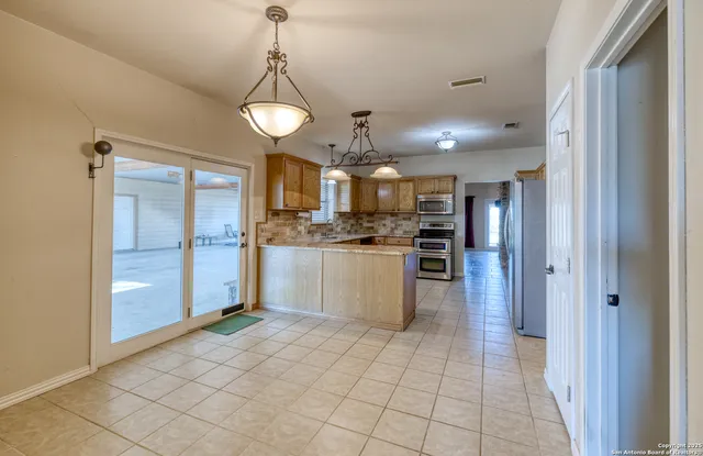 a kitchen with stainless steel appliances granite countertop a sink counter space cabinets and a stove