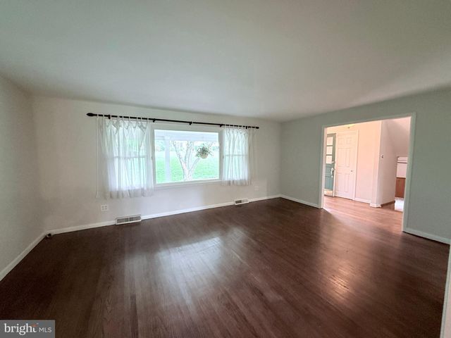 a living room with hard wood floors and a window