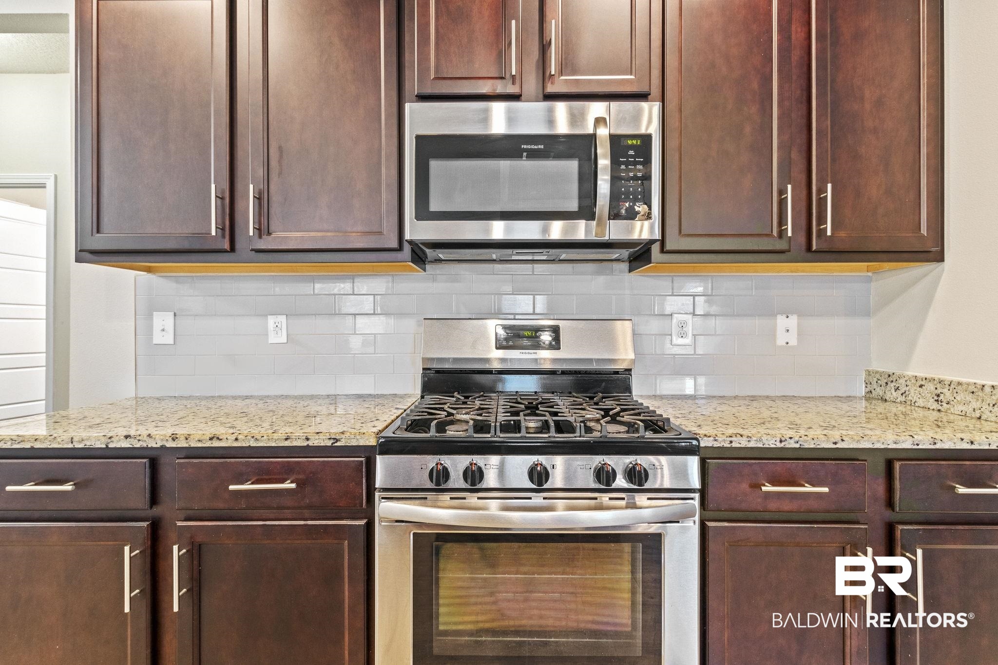 31643 Kestrel Loop Daphne, AL 36527 - Photo 12 of 59 Kitchen featuring backsplash, light stone countertops, and appliances with stainless steel finishes