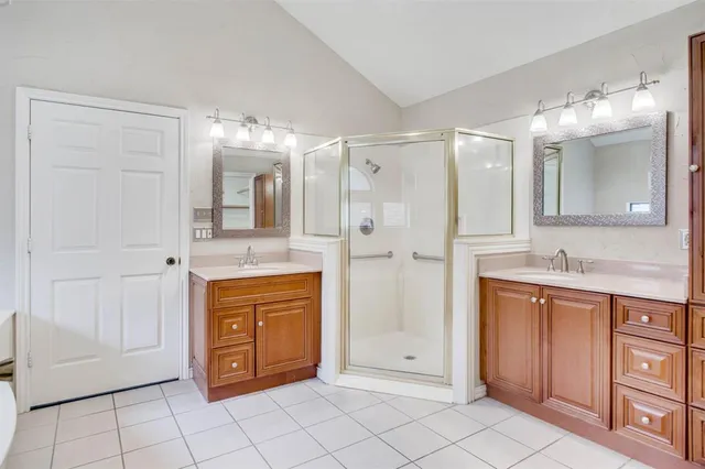 a bathroom with a double vanity sink mirror and shower