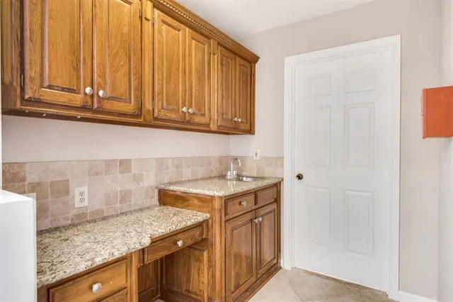 a kitchen with granite countertop a sink a stove and cabinets