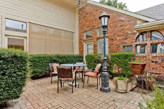 a view of a patio with chair and table potted plants