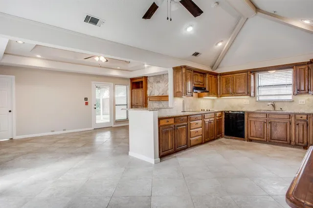 a large kitchen with stainless steel appliances granite countertop a large counter top a sink a stove and a window