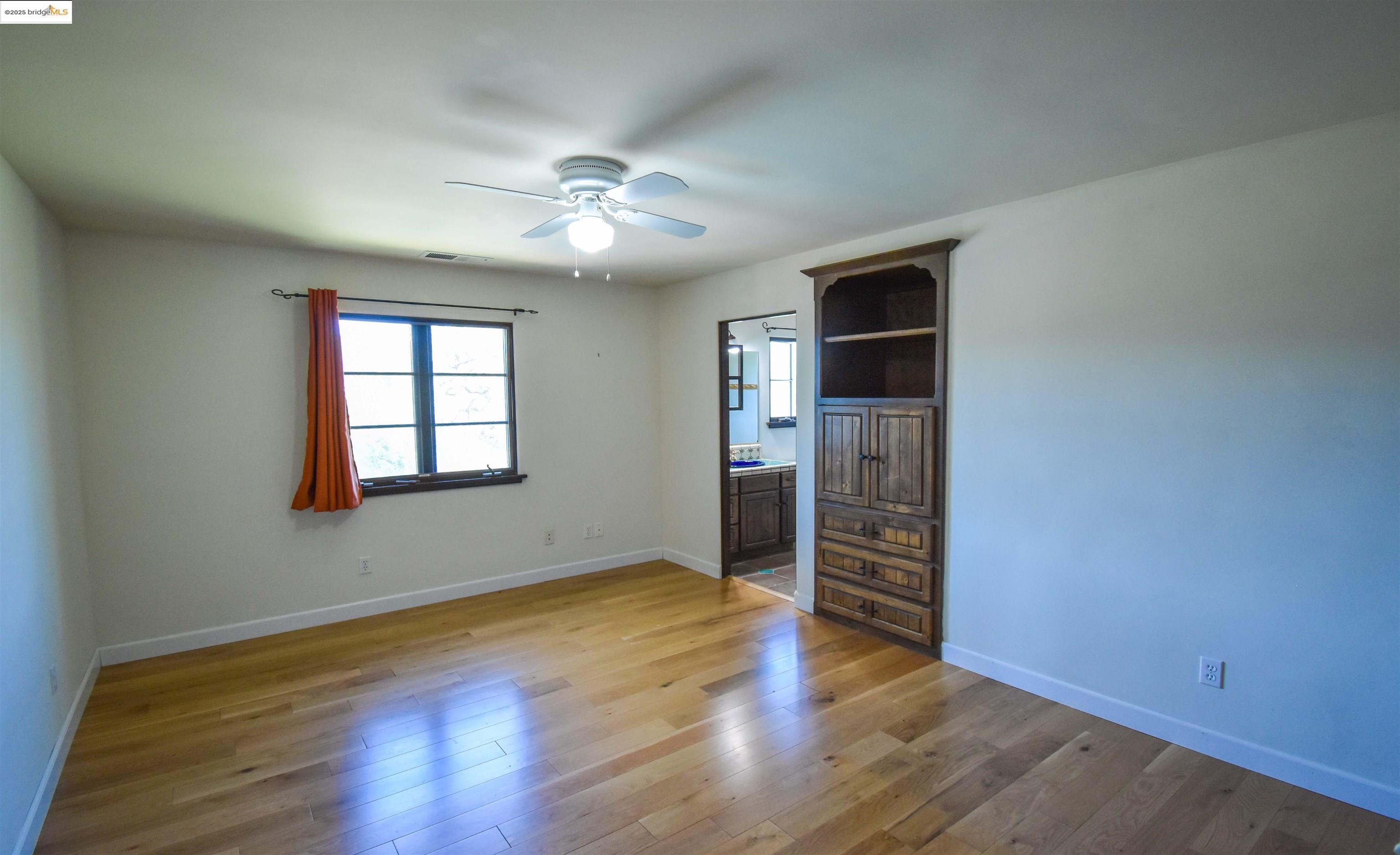 26255 Powell Ranch Road Sonora, CA 95370 - Photo 24 of 48 an empty room with wooden floor closet and windows