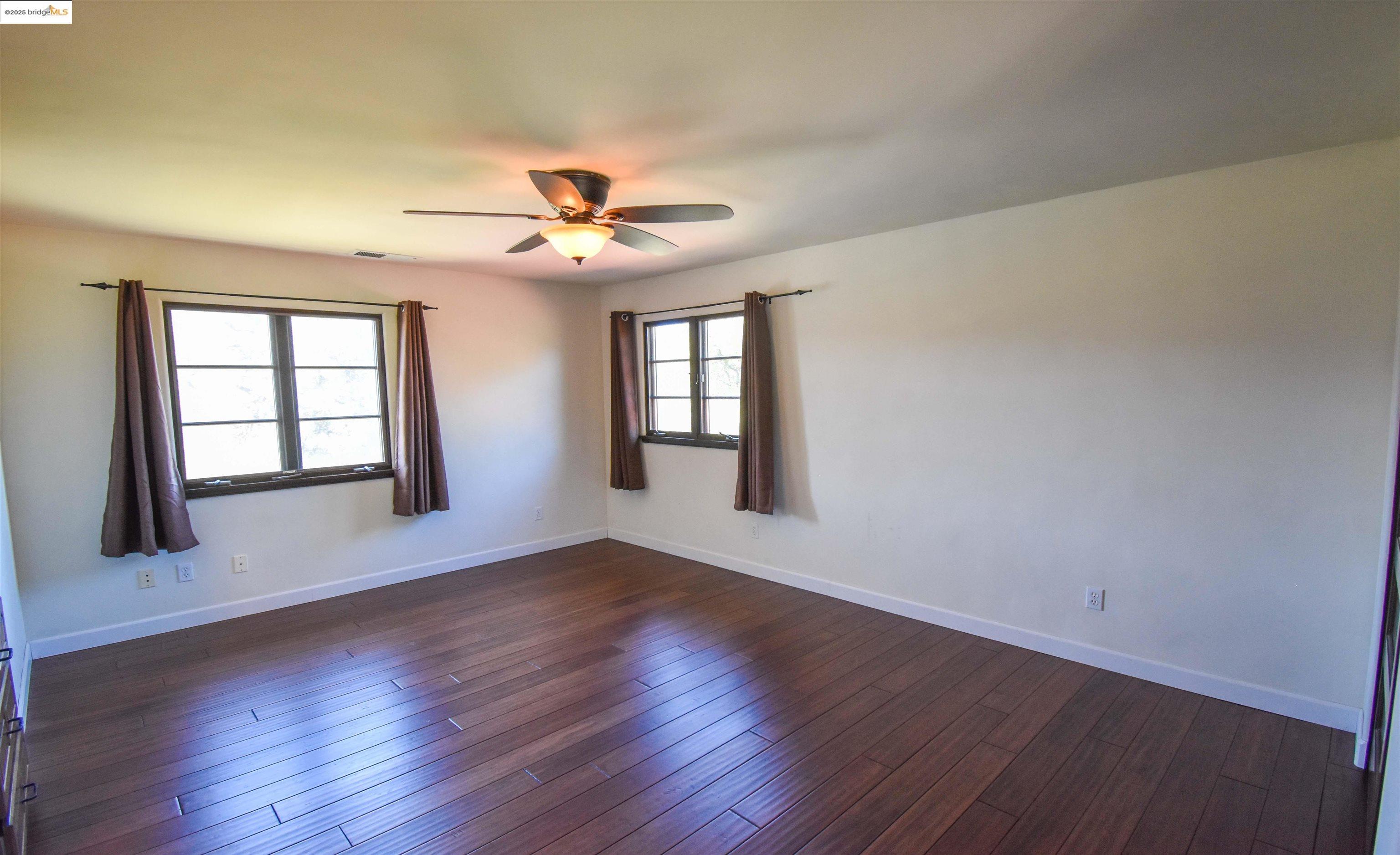 26255 Powell Ranch Road Sonora, CA 95370 - Photo 26 of 48 a view of an empty room with a window and wooden floor