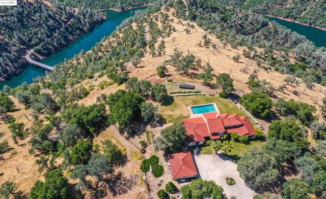 an aerial view of house with yard and swimming pool