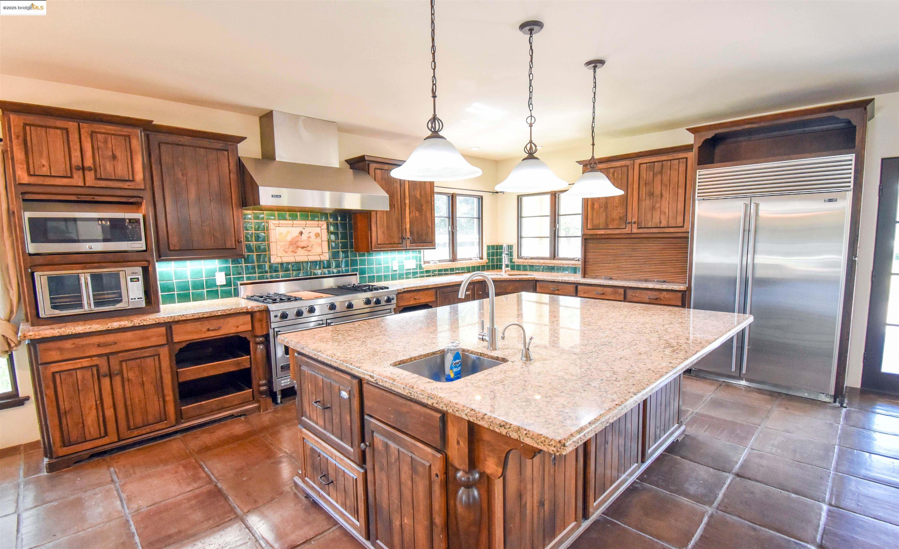 26255 Powell Ranch Road Sonora, CA 95370 - Photo 10 of 48 a kitchen with stainless steel appliances granite countertop a kitchen island a stove a sink a oven and a center island