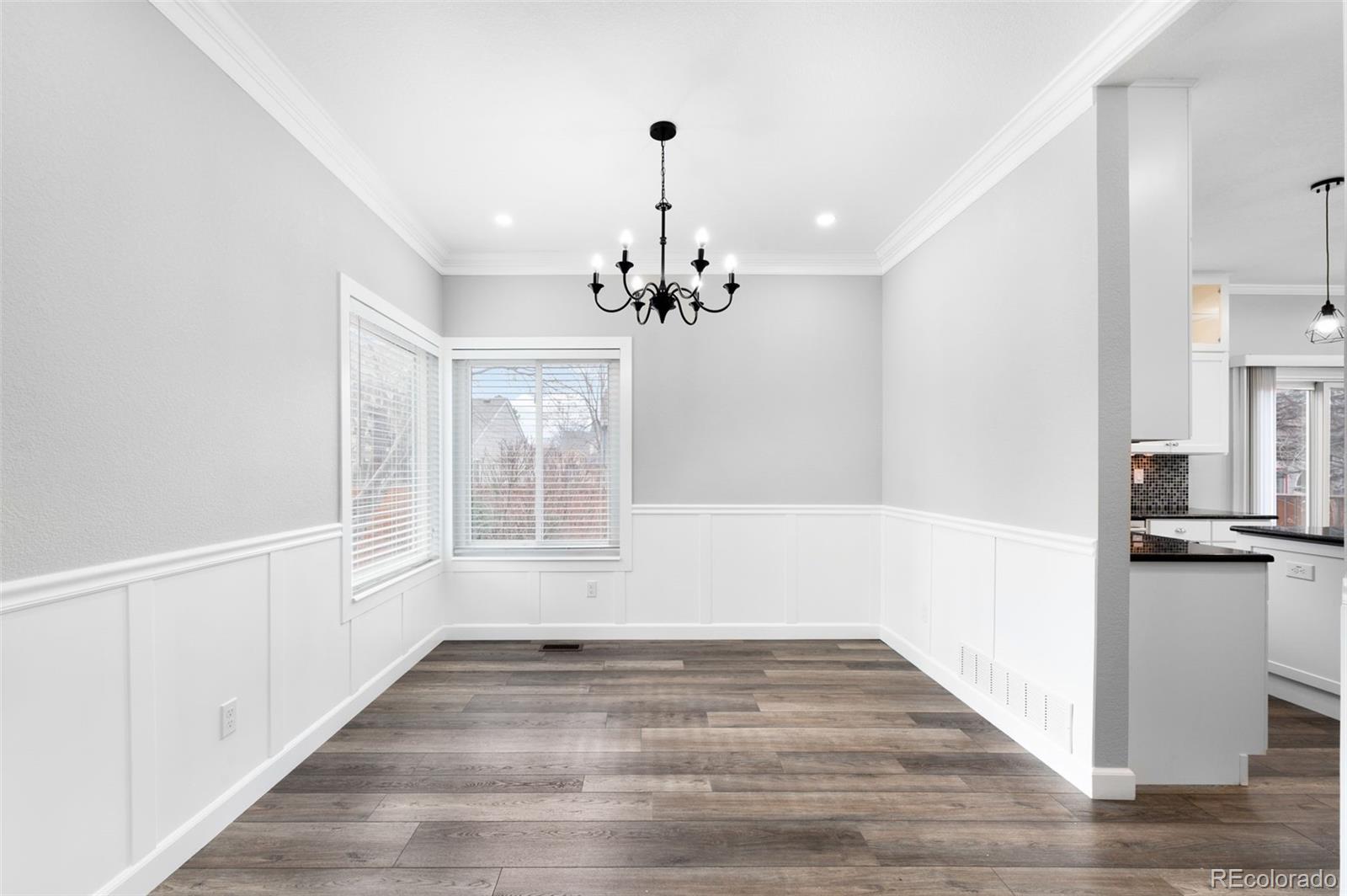 3618 West Rosewalk Circle Highlands Ranch, CO 80129 - Photo 14 of 45 a view of a hallway with wooden floor and a kitchen
