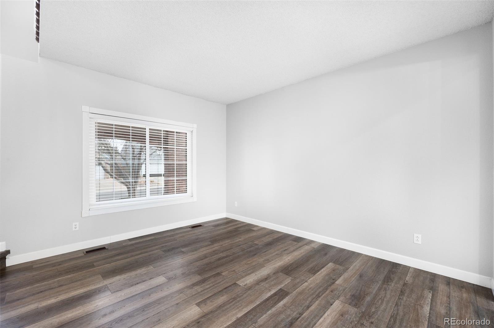 3618 West Rosewalk Circle Highlands Ranch, CO 80129 - Photo 10 of 45 an empty room with wooden floor and windows