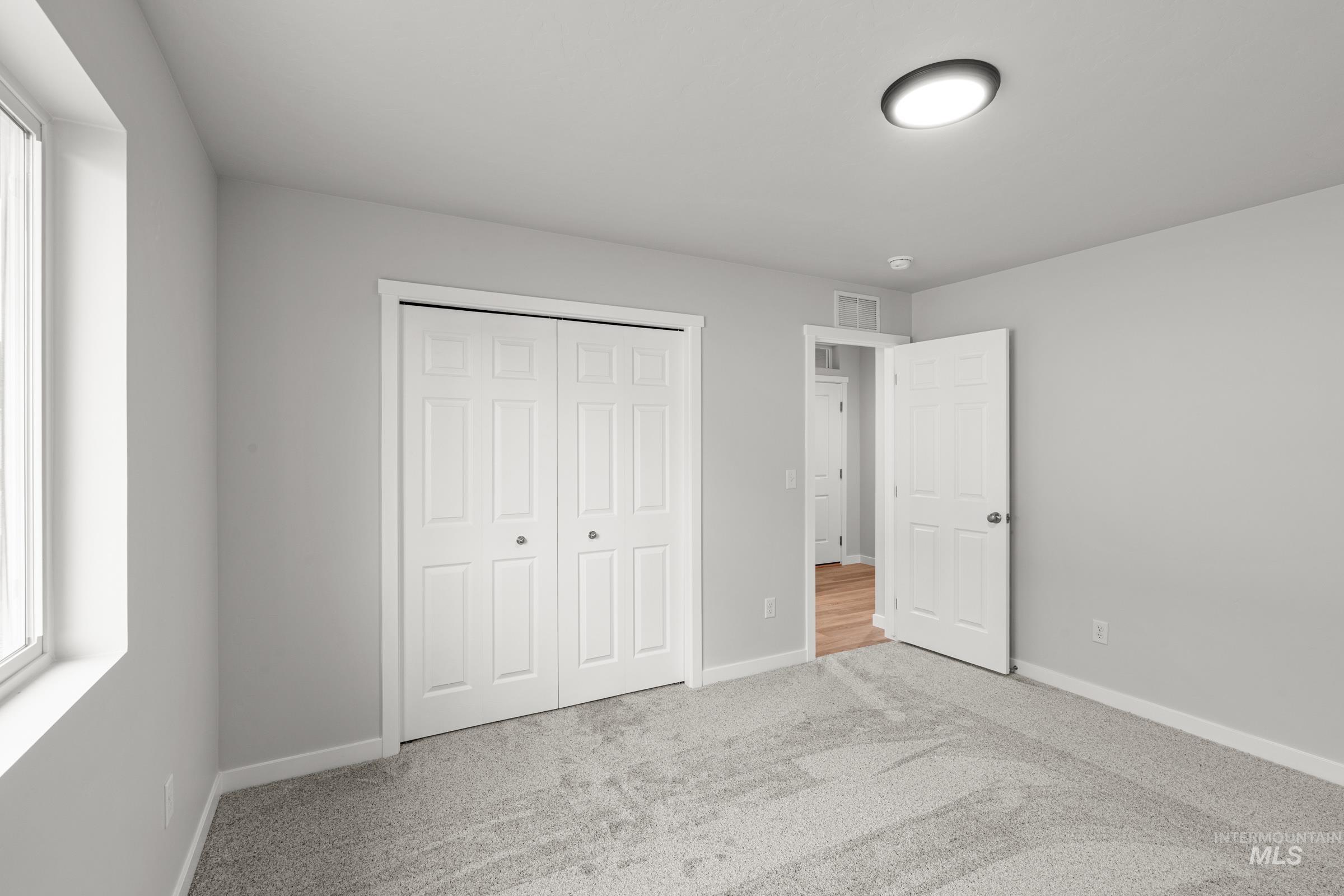 511 Hamlow Avenue Middleton, ID 83644 - Photo 13 of 22 Unfurnished bedroom featuring light colored carpet, multiple windows, and a closet