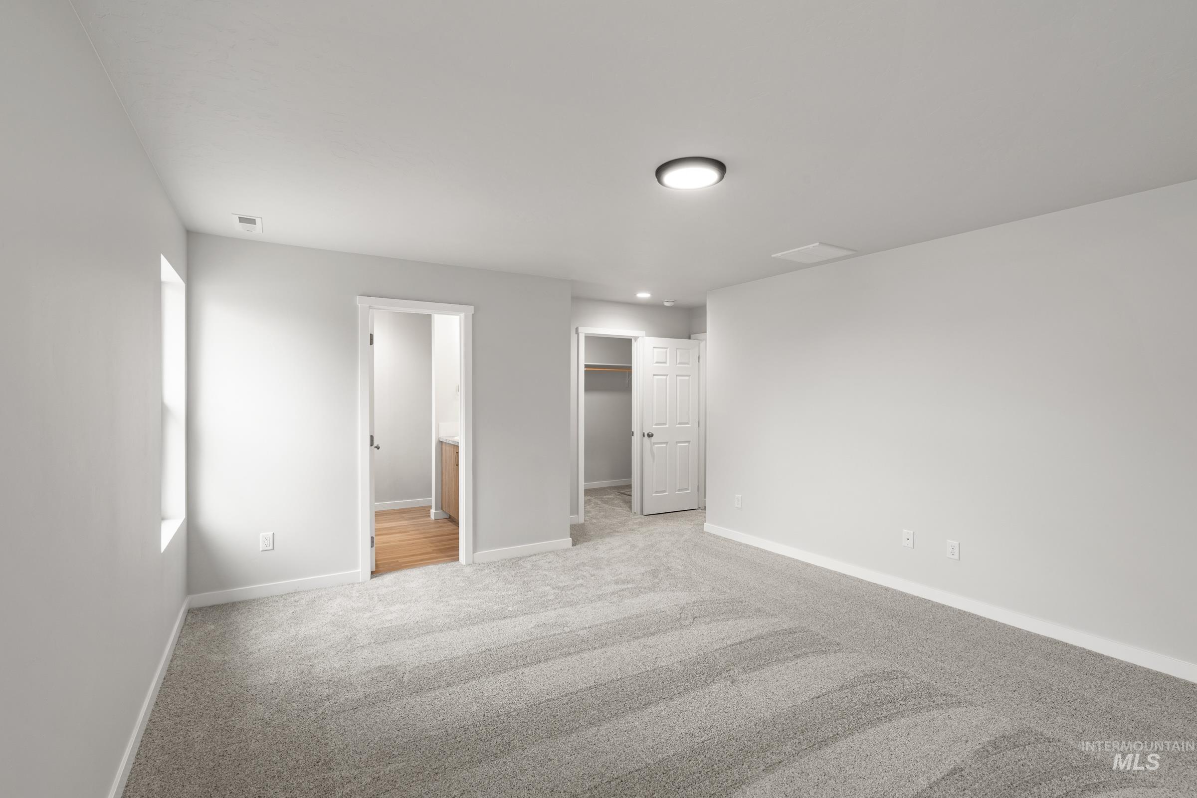 511 Hamlow Avenue Middleton, ID 83644 - Photo 16 of 22 Unfurnished bedroom featuring a spacious closet, ensuite bathroom, and light colored carpet