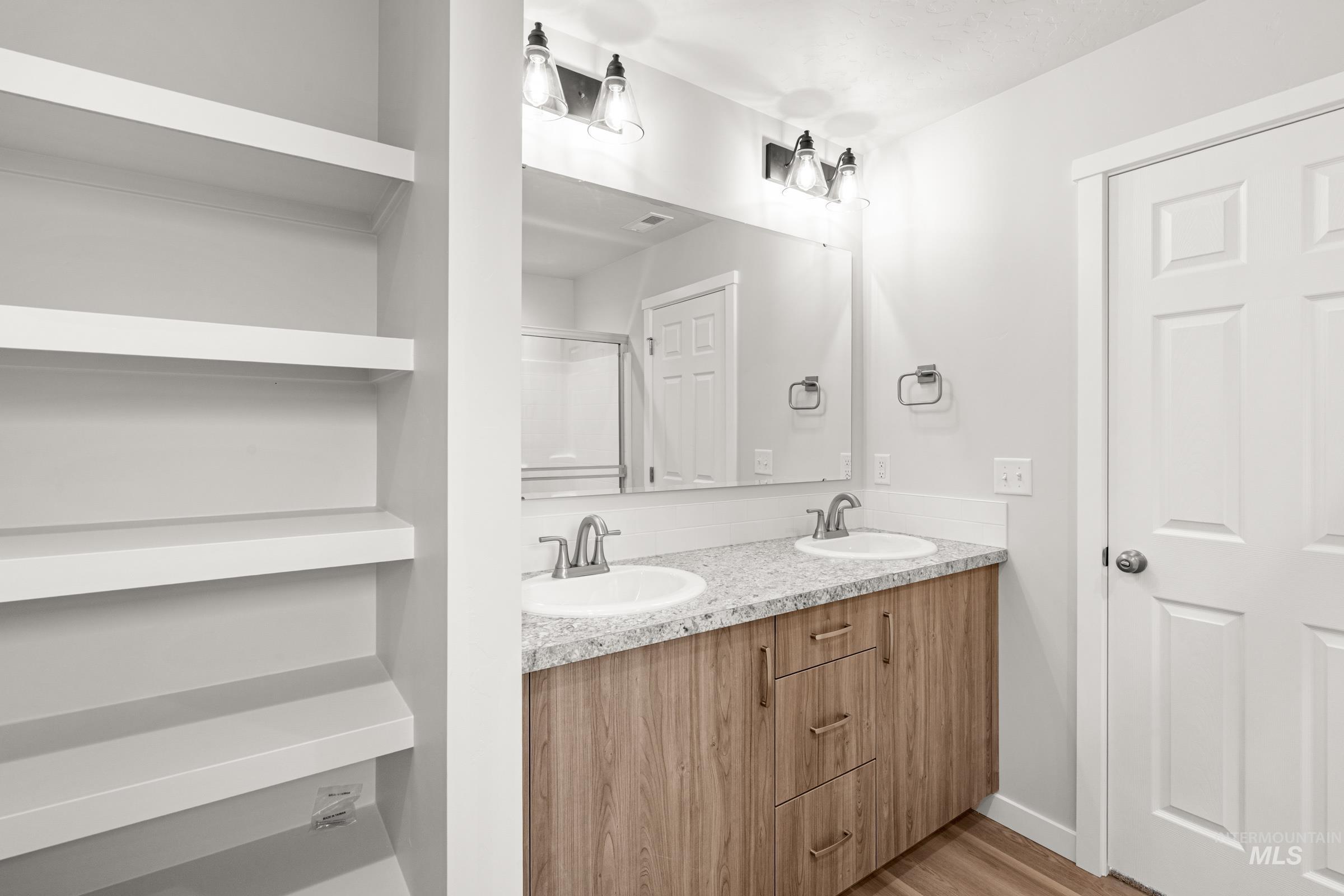 511 Hamlow Avenue Middleton, ID 83644 - Photo 20 of 22 Bathroom featuring double vanity, light wood-type flooring, and a shower with door