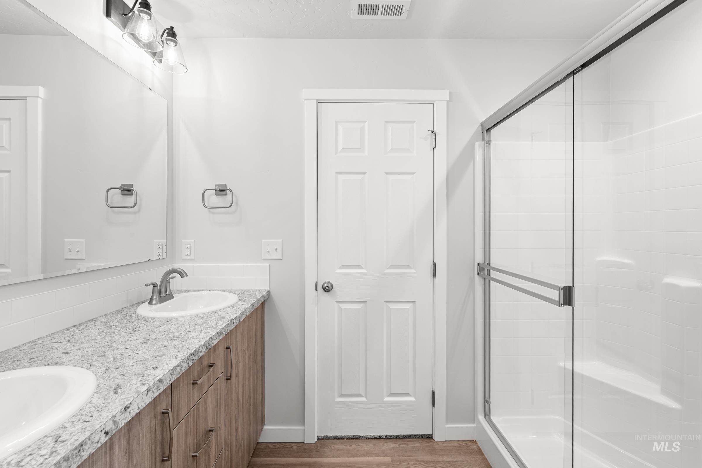511 Hamlow Avenue Middleton, ID 83644 - Photo 21 of 22 Bathroom featuring double vanity, a stall shower, and dark wood-style floors
