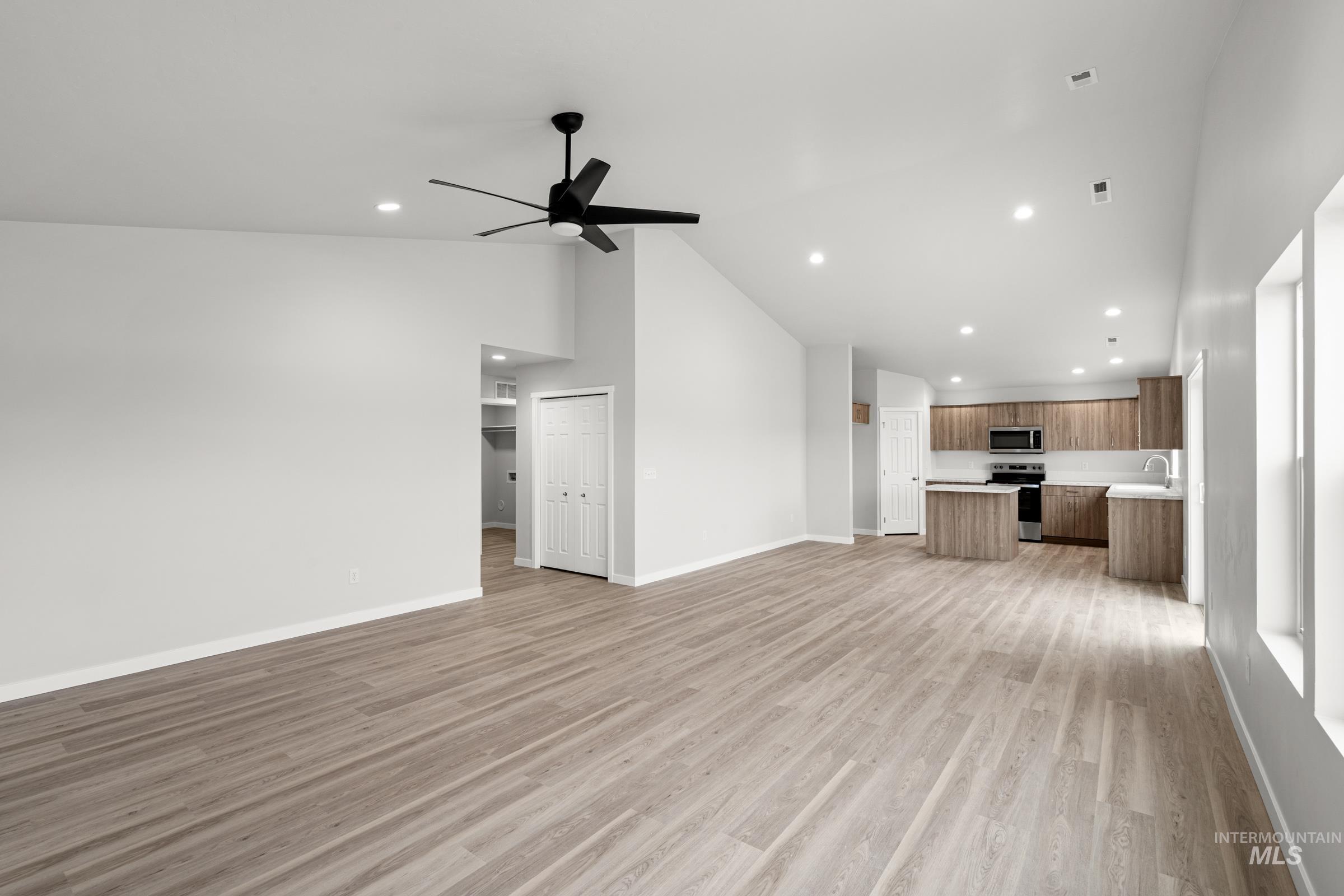 511 Hamlow Avenue Middleton, ID 83644 - Photo 9 of 22 Unfurnished living room with light wood finished floors, ceiling fan, lofted ceiling, and recessed lighting