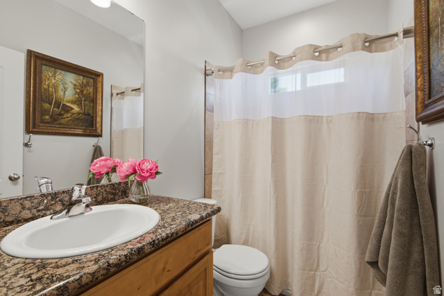 1252 Skyline Road Saratoga Springs, UT 84045 - Photo 24 of 51 Bathroom featuring a granite-finish countertop with an undermount sink, chrome faucet, wood-finish vanity, and a shower with tile surround