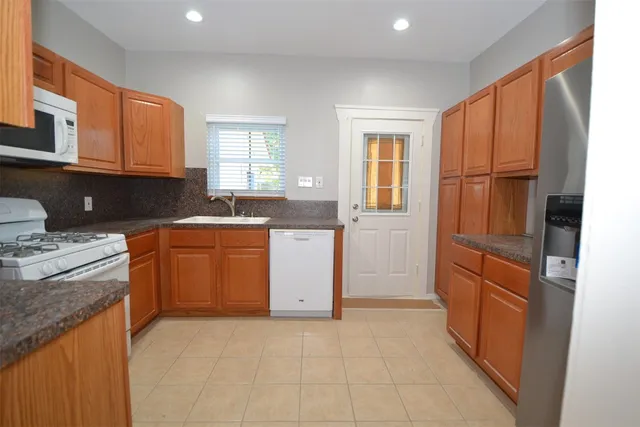 a kitchen with stainless steel appliances granite countertop a refrigerator and cabinets