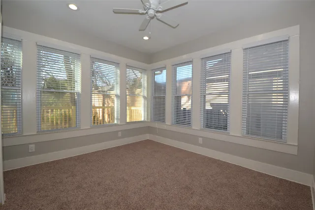 an empty room with a window and a ceiling fan