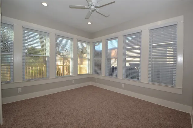 an empty room with a window and a ceiling fan