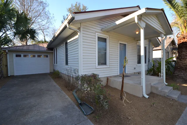 a view of a house with a yard and tree