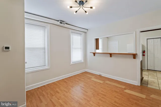 an empty room with a window and a ceiling fan