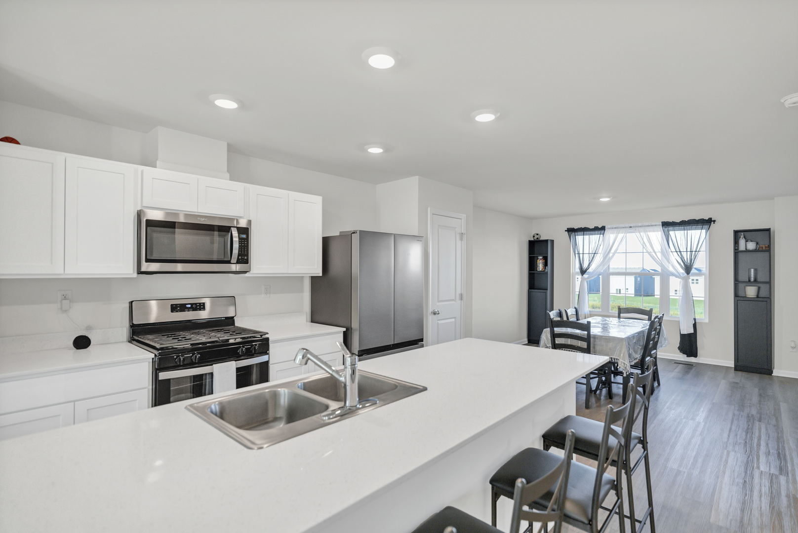 1464 Sequoia Way Hampshire, IL 60140 - Photo 15 of 31 a kitchen with stainless steel appliances a dining table chairs and refrigerator
