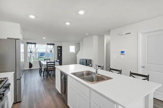 a kitchen with a table chairs stove and refrigerator
