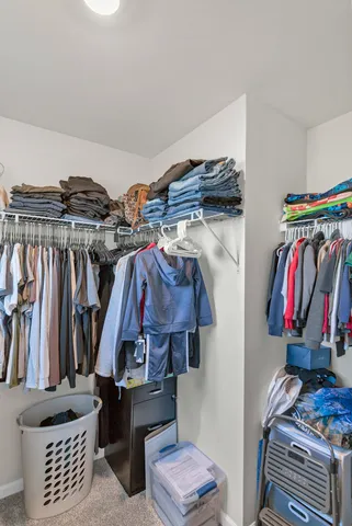 a view of walk in closet with clothes and shoes