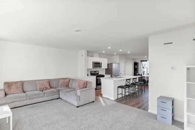 a living room with furniture and kitchen view
