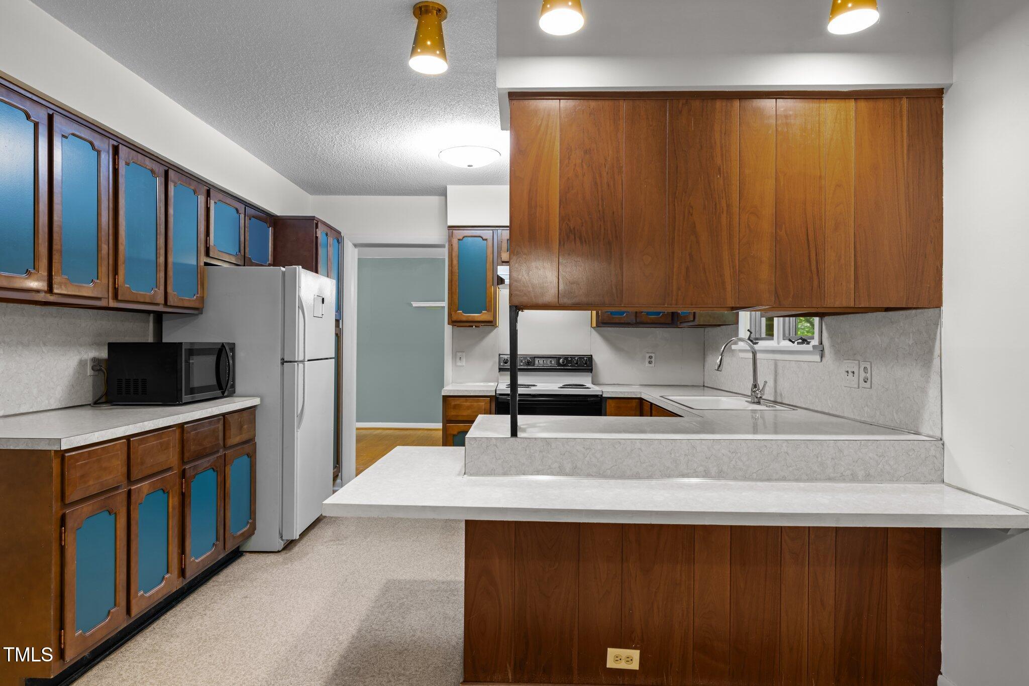 1024 Chalmers Street Durham, NC 27707 - Photo 14 of 41 a kitchen with stainless steel appliances a sink cabinets and a refrigerator