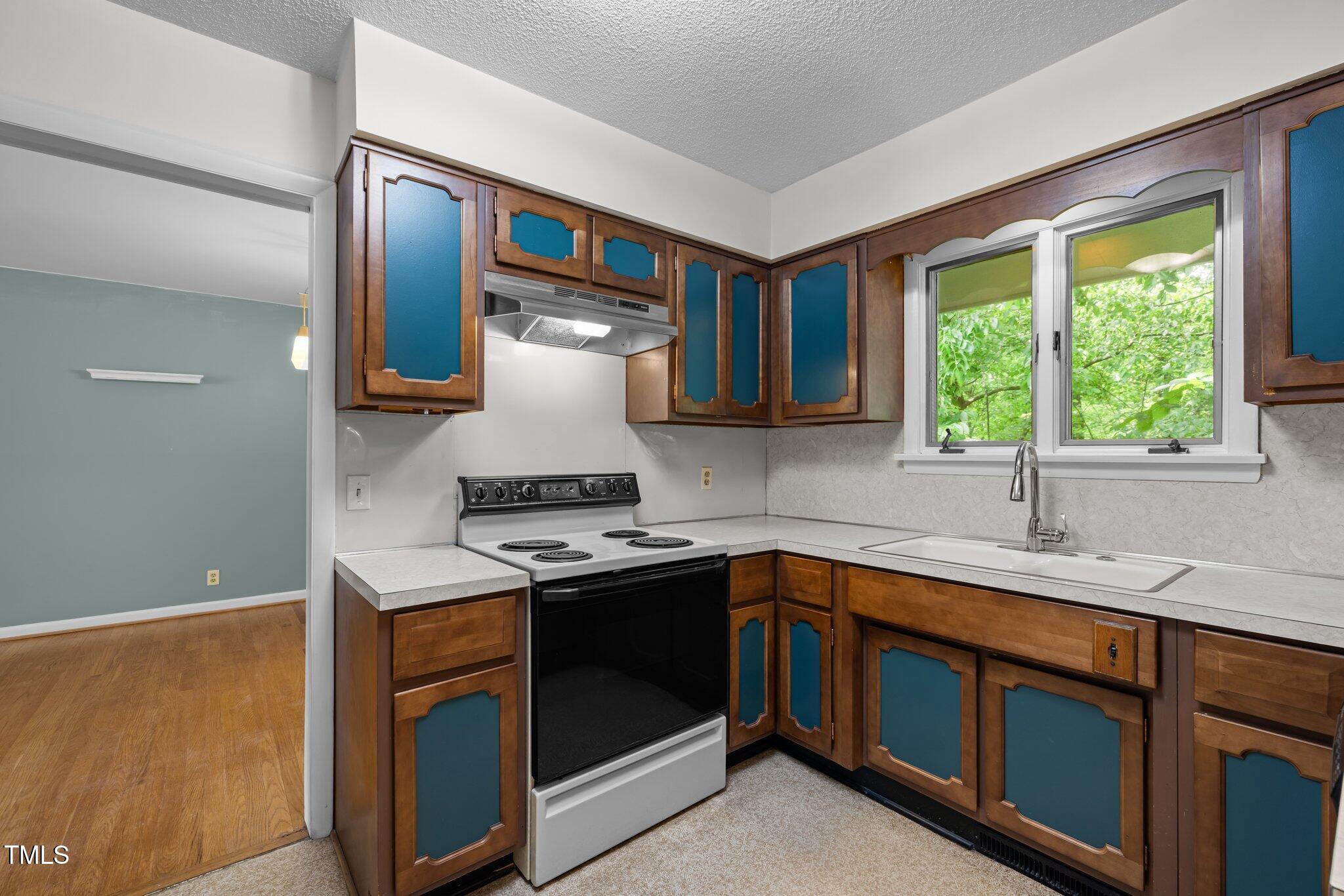 1024 Chalmers Street Durham, NC 27707 - Photo 16 of 41 a kitchen with a sink stove and cabinets