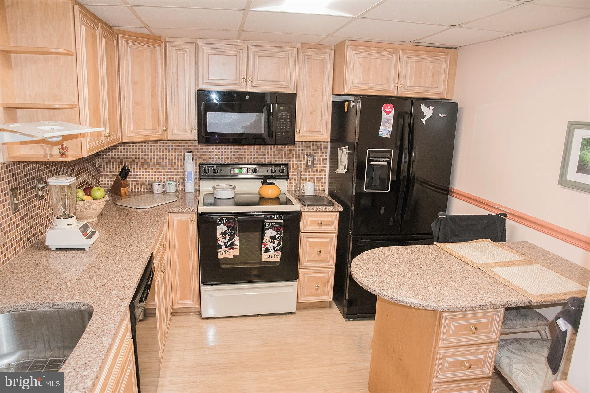 a kitchen with stainless steel appliances a stove a sink a microwave a refrigerator and cabinets