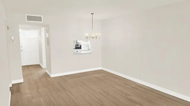 a view of a room with wooden floor and white walls