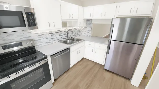 a kitchen with a refrigerator sink stove and cabinets