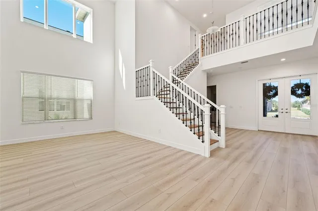 a view of an empty room with wooden floor and stairs