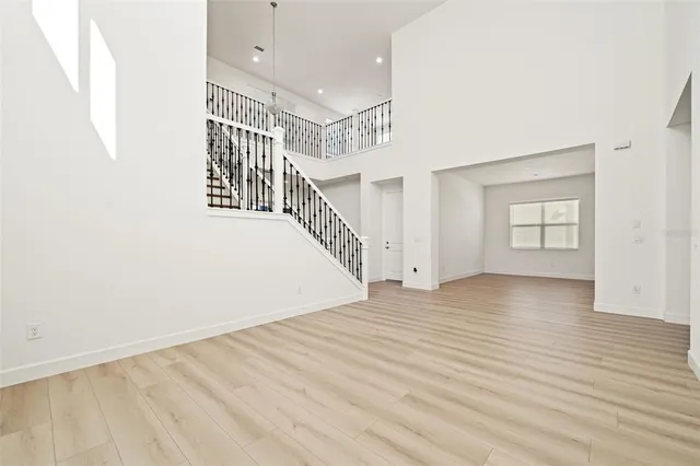 a view of an empty room with kitchen and a window