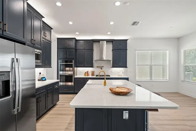 a kitchen with refrigerator a sink and chairs