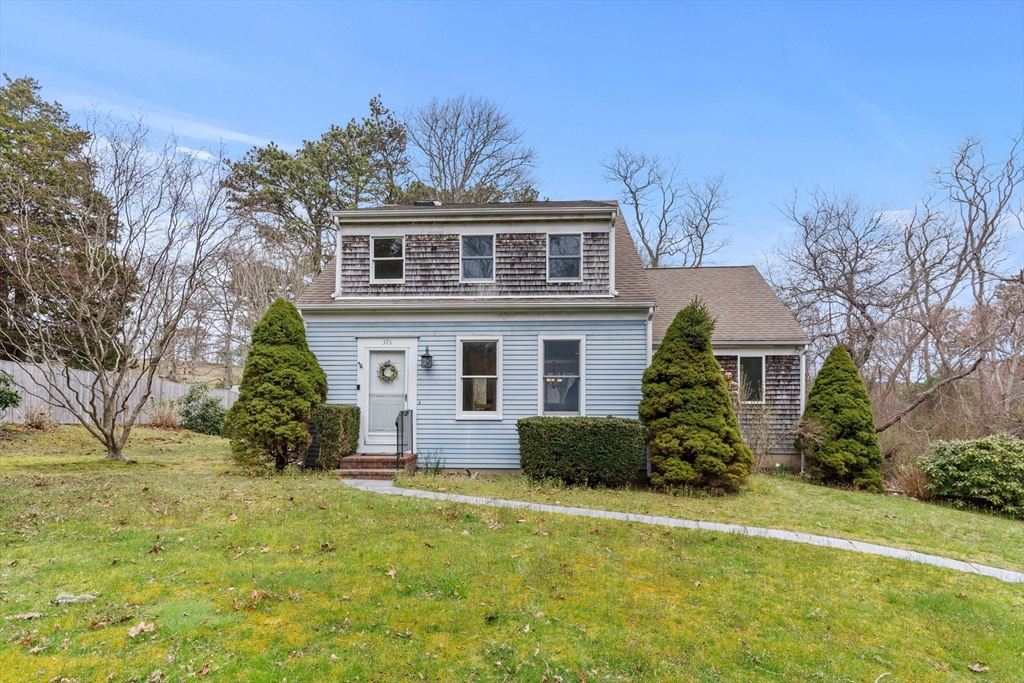 376 Pleasant Bay Road Harwich, MA 02645 - Photo 1 of 17 a front view of house with yard and trees around
