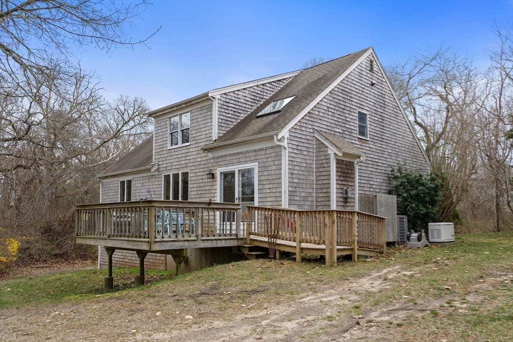 376 Pleasant Bay Road Harwich, MA 02645 - Photo 14 of 17 a view of a house with a wooden deck and a backyard