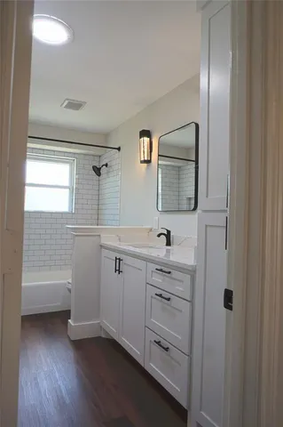 a bathroom with a sink a light fixture and a mirror
