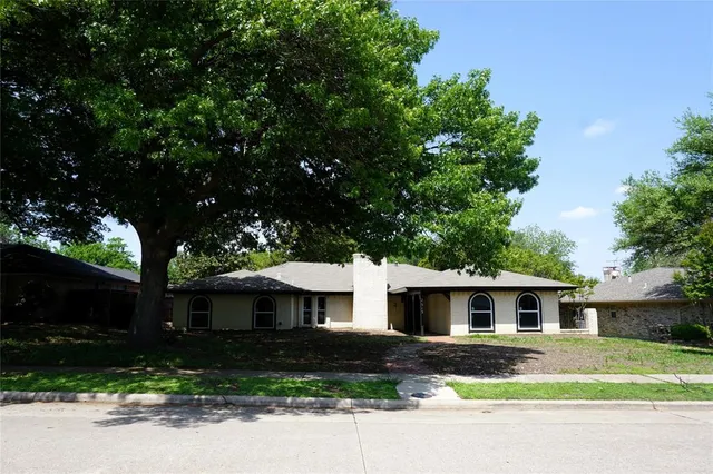 a front view of a house with yard and trees