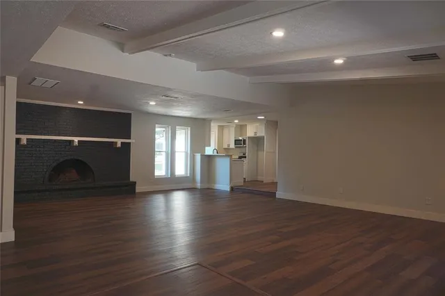 a view of a hallway with wooden floor and a fireplace