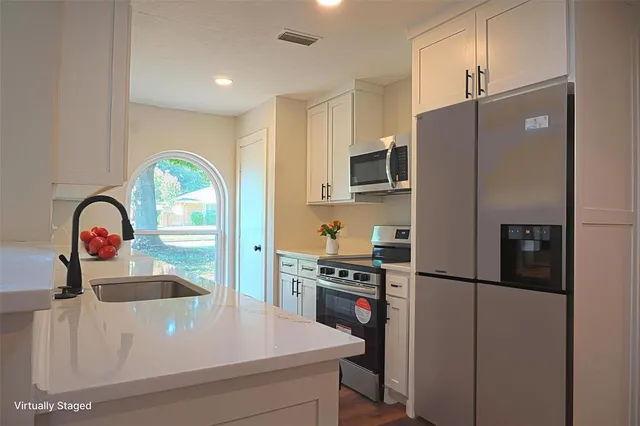 a kitchen with stainless steel appliances granite countertop a refrigerator and a stove