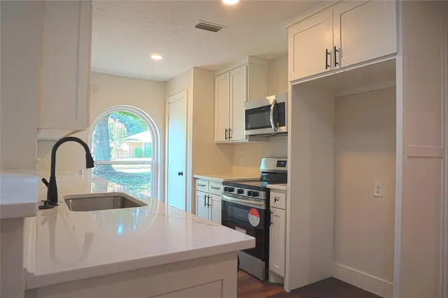 a close view of a sink a stove and refrigerator