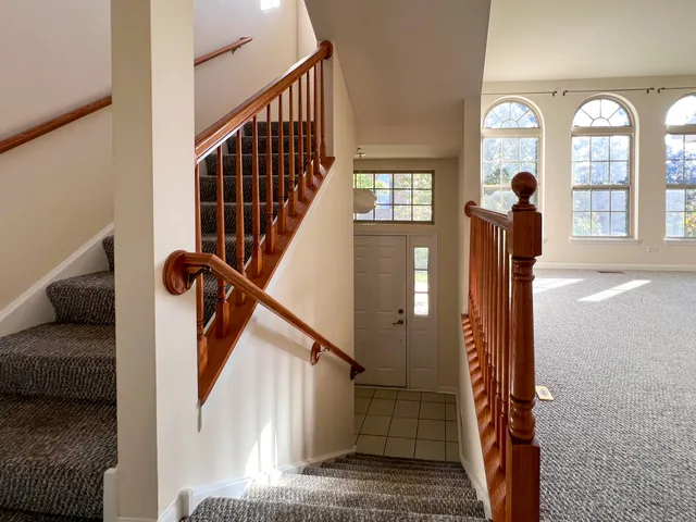 an empty room with windows and ceiling fan