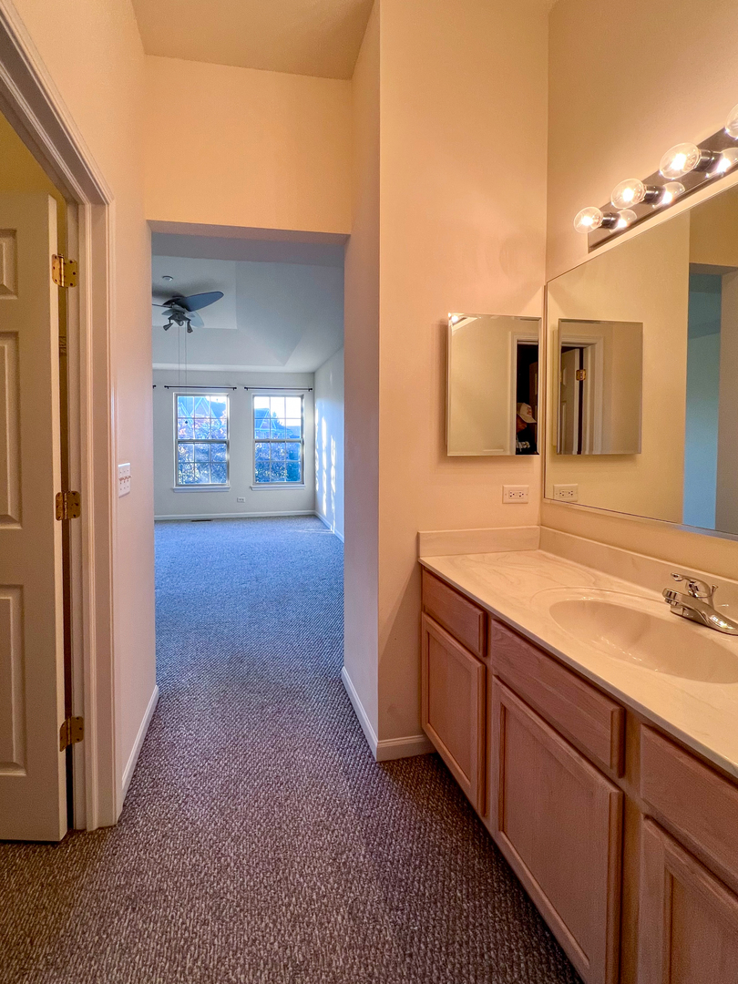 554 Prestwick Lane, Unit 554 Wheeling, IL 60090 - Photo 16 of 30 a view of a bathroom with a sink and mirror