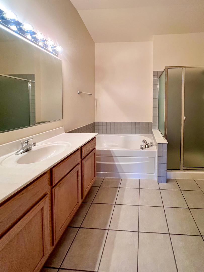 554 Prestwick Lane, Unit 554 Wheeling, IL 60090 - Photo 17 of 30 a bathroom with a sink a mirror and a bathtub